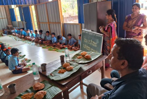 Education officer enjoys a hot meal with children!
